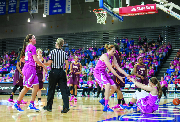 EMMA DONAHUE, Drake’s lone senior, helps Caitlin Ingle off of the Knapp Center floor during the annual Pink Game on Feb. 26, the first of four Bulldog wins to finish the regular season. PHOTO BY MOHAMAD SUHAIMI | STAFF PHOTOGRAPHER