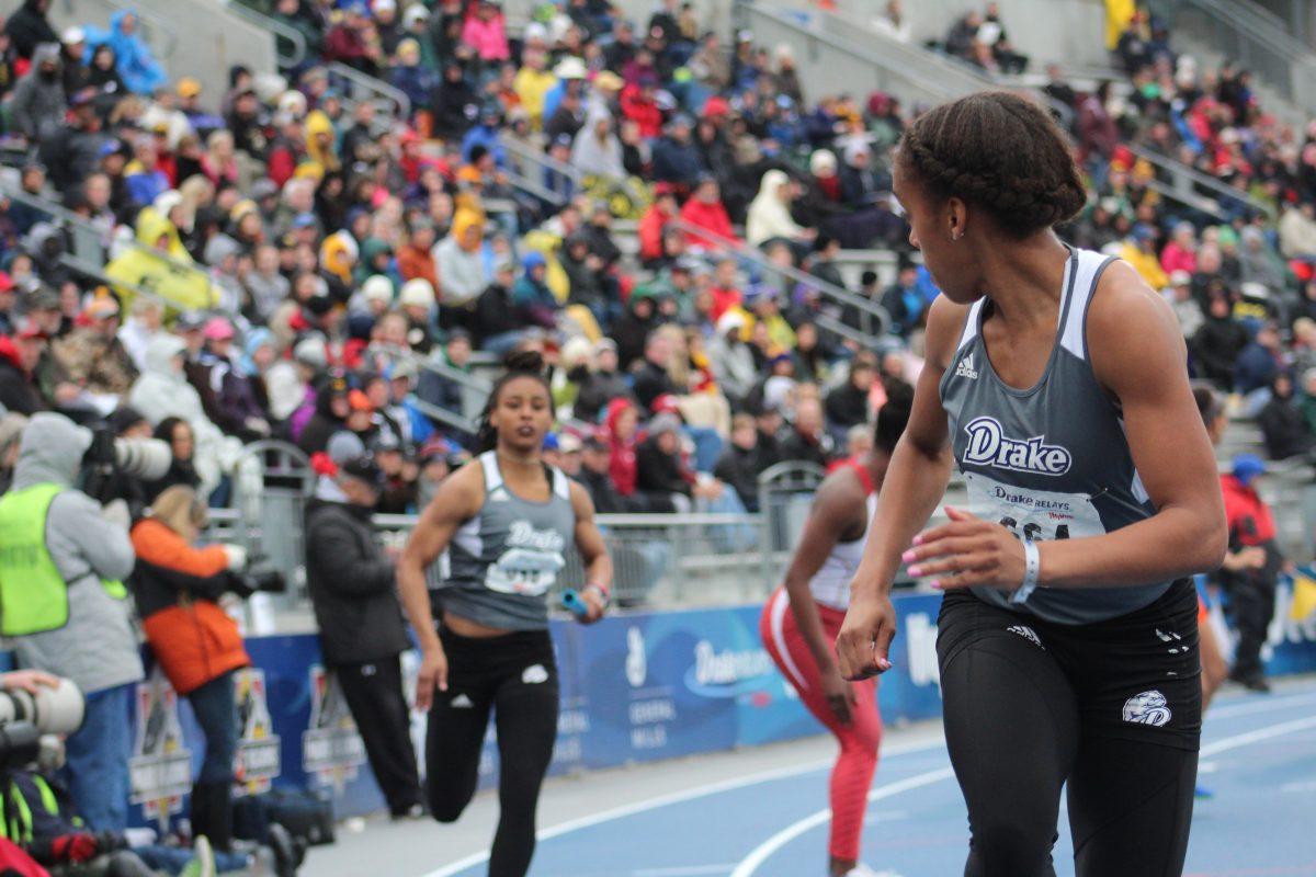 In the women's university 4x100, Drake junior Rai Ahmed-Green finishes her leg as Mary Young begins hers. Photo by Adam Rogan