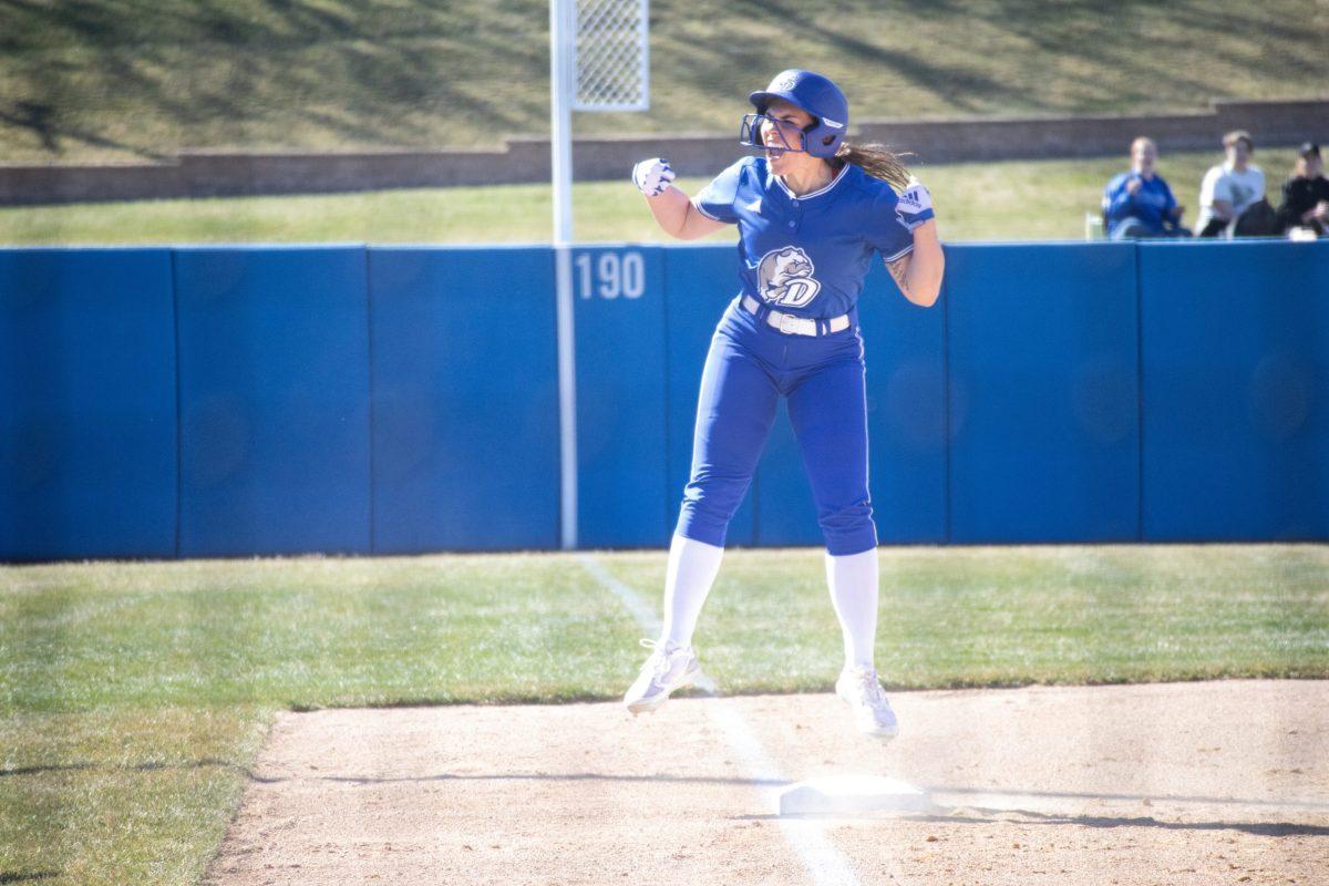 A Drake softball player celebrates on third base