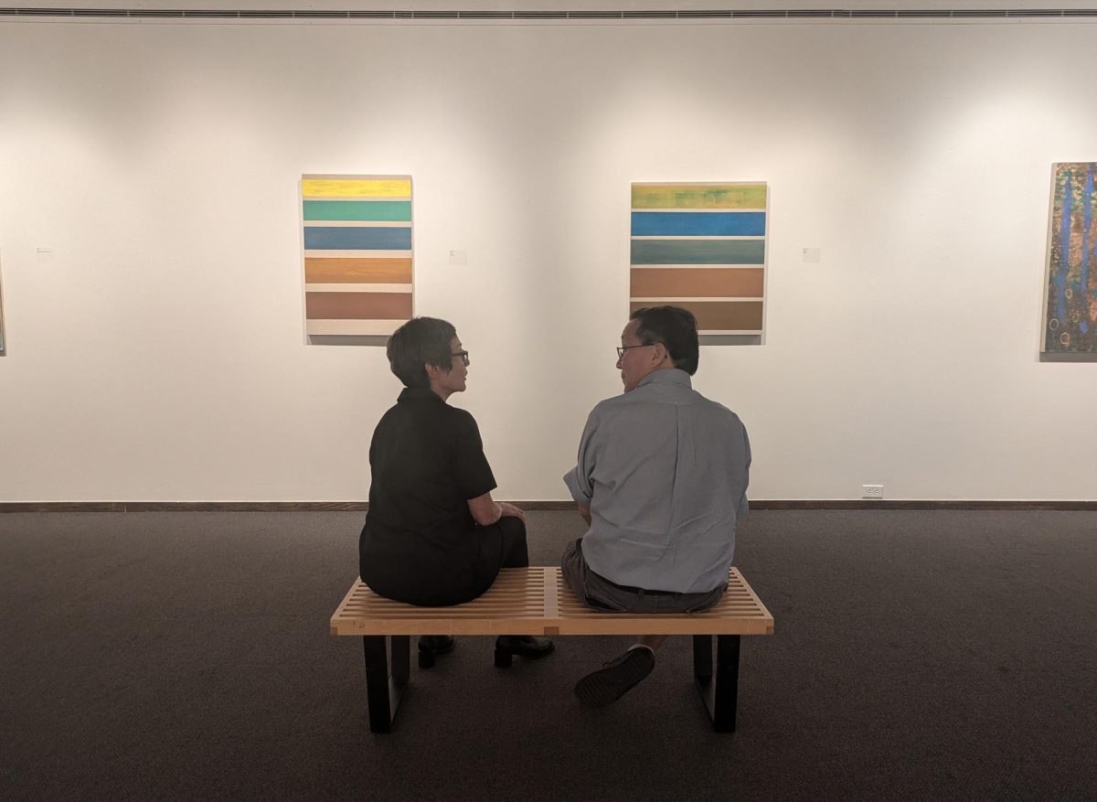 Artist Kim Uchiyama sits with her cousin, who came to support her on the opening night of her exhibit. Uchiyama's art explores the concept of time.