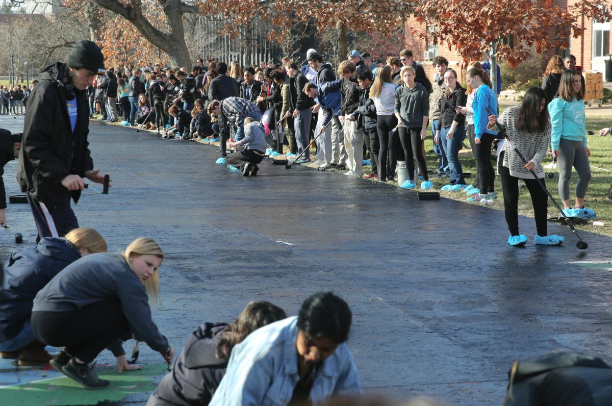 At the first #PaintItBlack in 2018, students covered Painted Street in black paint to show solidarity with students of color on campus. Photo courtesy of Drake University Archives.