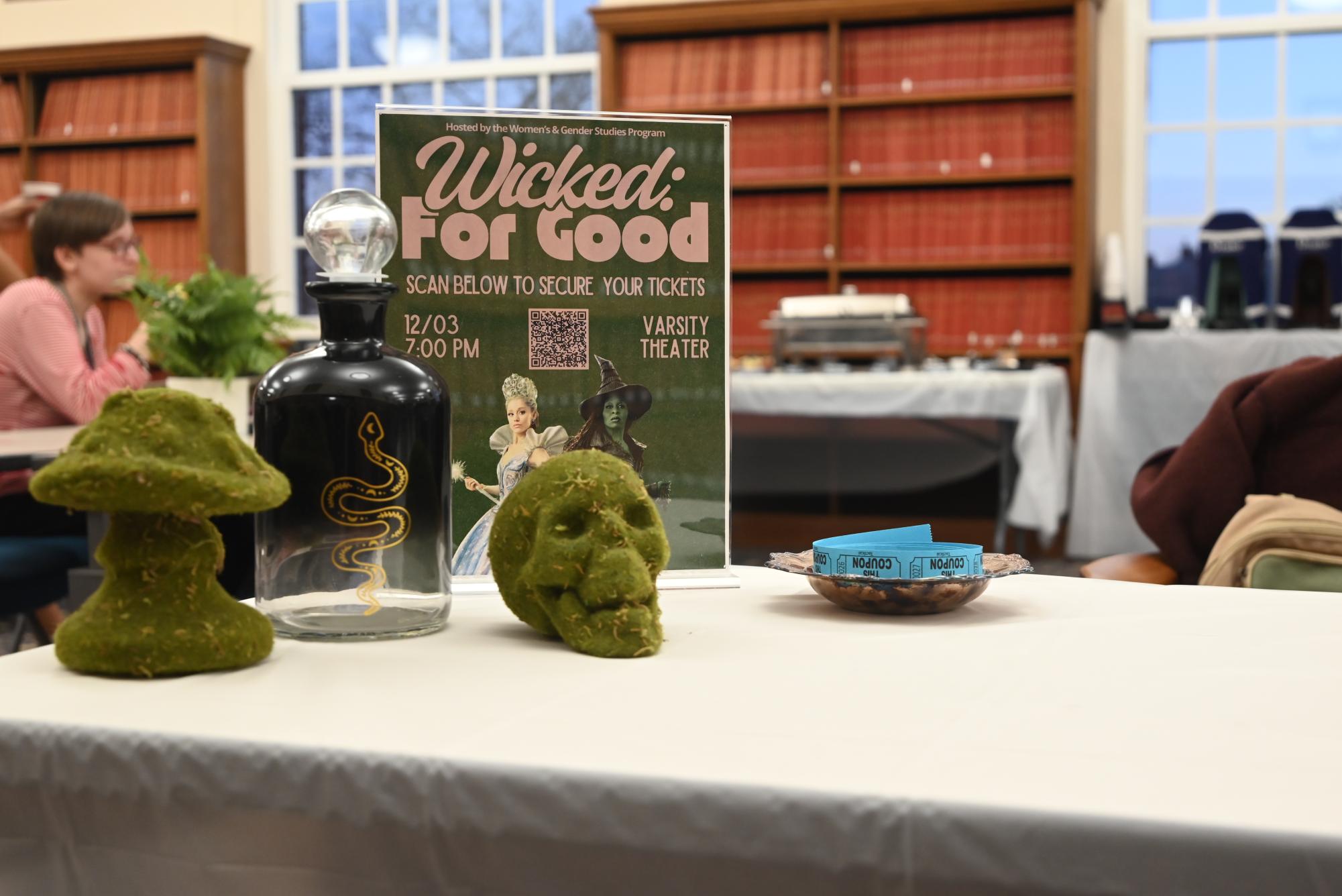 A promotional poster and decorative cauldron sit on the table at the entrance of the WGS program’s tarot reading event on Nov. 13.
